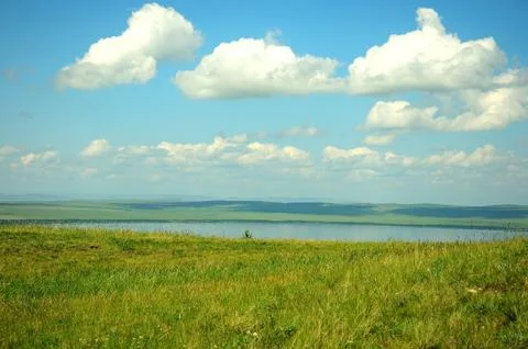 Long steppe and several small houses on the side of a hill on the shore of a Stock Photos
