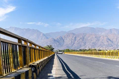 Long straight empty road on bridge leading towards mountains conceptualizin.. Stock Photos