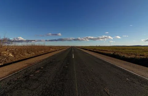 Long straight road between fields in Spain Stock Photos