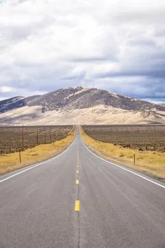 A long, straight road heading into the distant mountains 스톡 사진