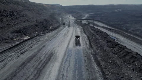 Long stretch of coal mine road with heavy machinery under a clear sky Stock Footage 275010069