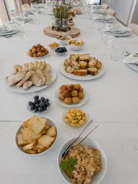 A long table in a bright dining room is set for a group gathering Stock Photos