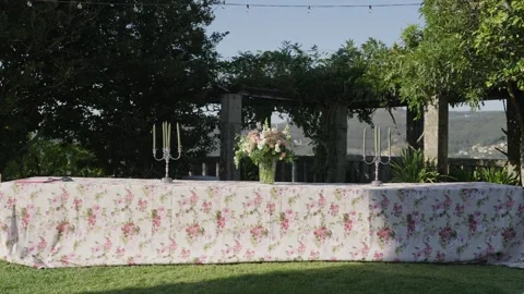Long Table With Floral Tablecloth and Silver Candelabras Stock Footage 346787358
