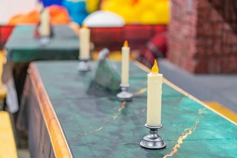Long table with a green marble surface, six white taper candles in silver hol Foto stock