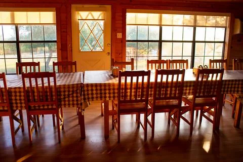 Long table with tablecloth in rustic home at sunset Stock Photos