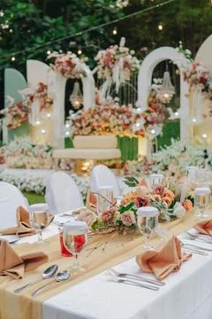 Long table with white table cloth and an elegant floral arrangement in the .. 스톡 사진
