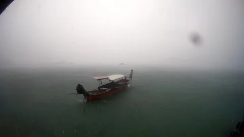 Long tail boat floating in the sea while raining, Phuket, Thailand Video stock 248039058