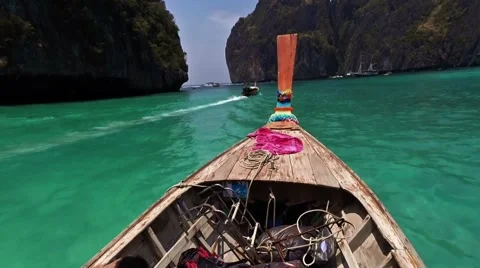 Long tail boat heading to Phi Phi Island, Thailand. Man enjoying the sun sitting Stock-Footage 62882975