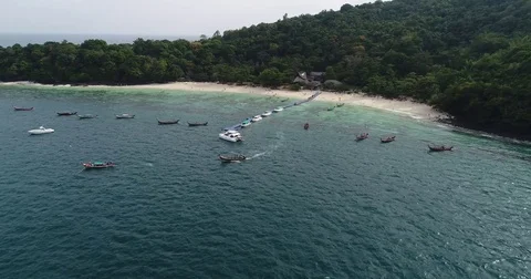 Long-Tail Boat Leaving a Thai Island Beach Near Anchored Vessels Vídeo Stock 71301711