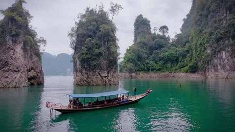 Long-Tail Boat Passing Between Limestone Karsts on Cheow Lan Lake in Khao Sok Stock Footage 313124653