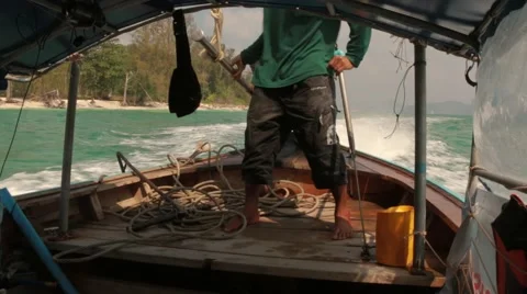 Long-tail boat pilot controls the outboard motor while driving in Ao Nang, Krabi Stock Footage 50410635