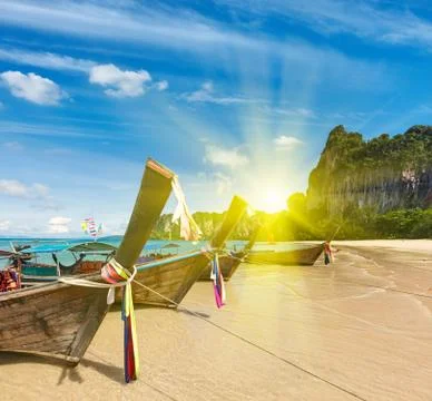 Long tail boats on tropical beach in Thailand oin sunset Stock Photos