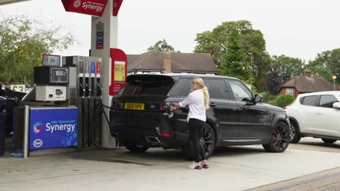 Long tailback of vehicles queuing on the road outside an Esso filling station Stock Footage 163344808