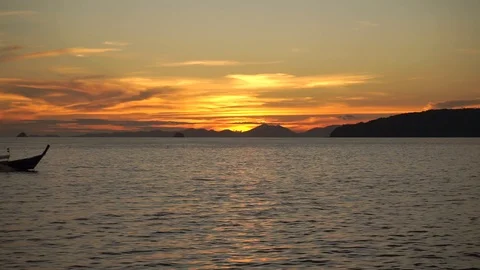 Long-tailed boats float on calm water at sunset Stock Footage 109122105
