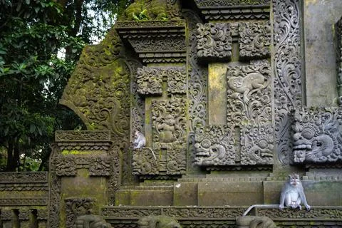 Long-Tailed Macaques Rest on Ornate Balinese Temple Foto stock