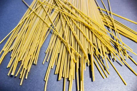 Long thin spaghetti is scattered on the table. Stock-Fotos
