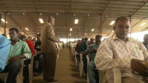Long track through seated men, Nigerian mega church Stock Footage 38482756