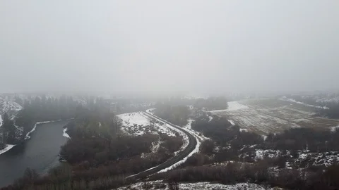 Long tracking shot over a snow covered valley being cut through by a train tr Stock Footage 124616321