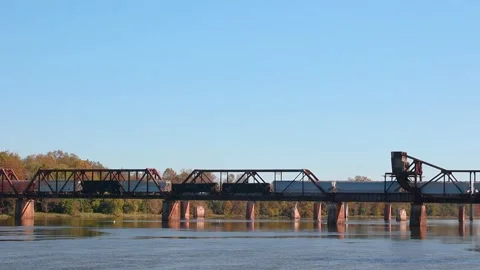 A long train passes over an old bridge slowly Stock Footage 143441447