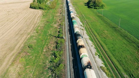 A long train set goes on a railway, top view. Aerial view of train at sunset Stock Footage