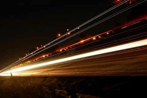 A long train track with a bright light shining on it Stock Photos