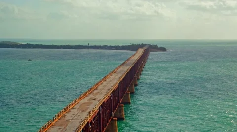 A long utility pipe line bridge on an ocean at sunrise Stock Footage 61304807