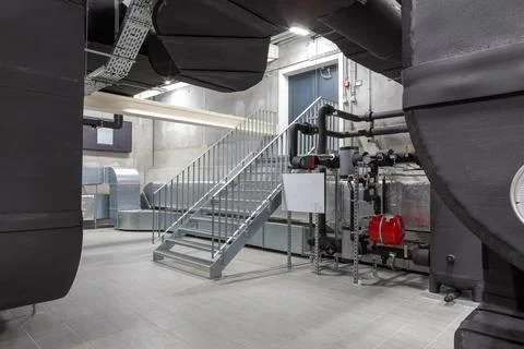 An long ventilation pipe in a technical room in the basement of a large bui.. Stock Photos