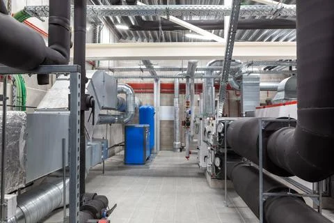 An long ventilation pipe in a technical room in the basement of a large bui.. Foto stock