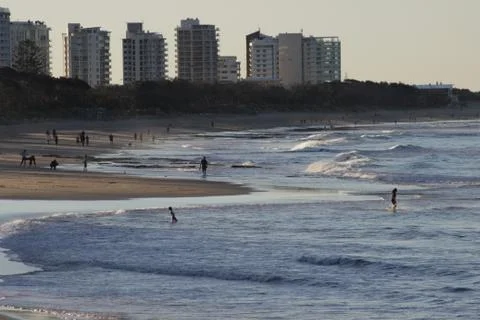 Long view of beach, trees and buildings with people Stock Photos