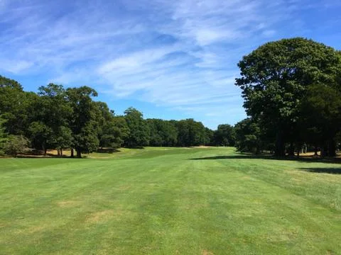 Long view down the fairway of a golf course hole on a beautiful autumn day Stock Photos