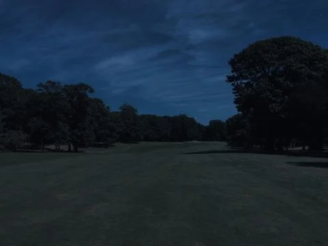 Long view down the fairway of a golf course hole on a beautiful summer night Stock Photos