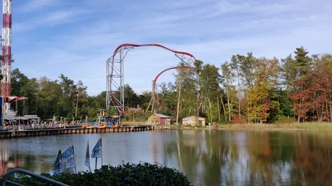 A long view of  rollercoaster Sky Scream with park trees reflection in the Stock Footage 120754119