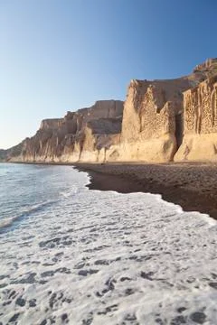 The long Vlychada Beach of Santorini with its impressive pumice cliffs in eve Stock Photos