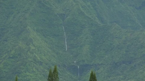 Long waterfall flows down large island mountain A Stock Footage 125340499