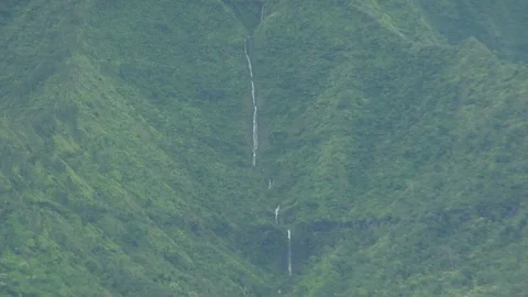 Long waterfall flows down large island mountain C Video stock 125340505
