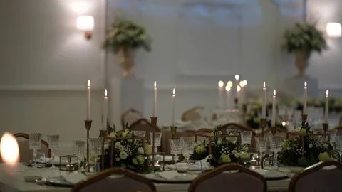 Long wedding dining table with candelabras florals and crystal glasses Stock Footage 333413842