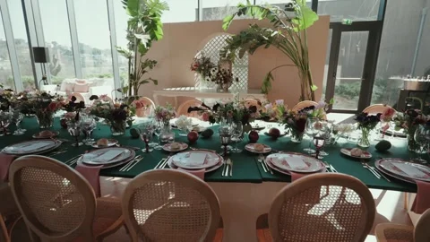 Long wedding table with floral decorations and place settings indoors 库存影片 332819099