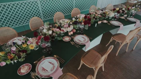 Long wedding table setup with floral centerpiece and tableware Stock Footage 333107903