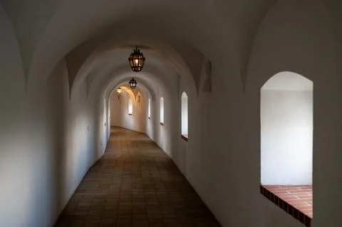 Long white arched monastery corridor with tiled floor and soft light, peacefu Stock Photos