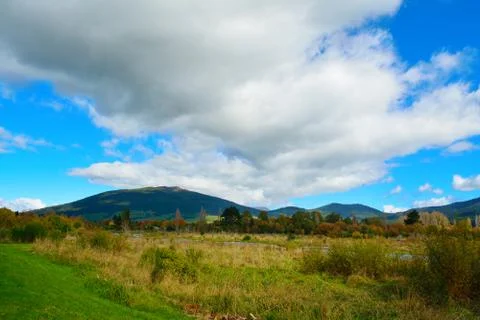 Long white cloud spreading over banks of Tongariro river on a bright autumn day. Stock Photos