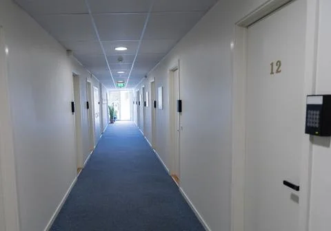 Long white corridor with a window at the end in a hotel. Stock-Fotos
