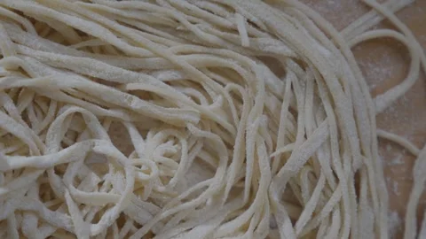 A long white noodle is shown in a close up Stock Footage 306042753