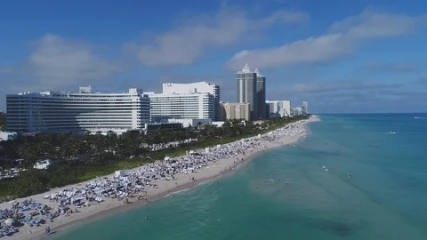 Long white oceanfront hotel and busy sand at Miami Beach Vídeo Stock 85827760