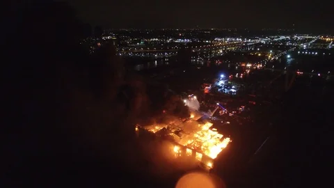 Long wide aerial sequence of fire engulfing large recycling facility in Toronto Stock Footage 92644078