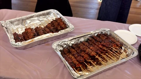 A long wooden table is laden with various food items, including large plates of  Stock Footage 334350111