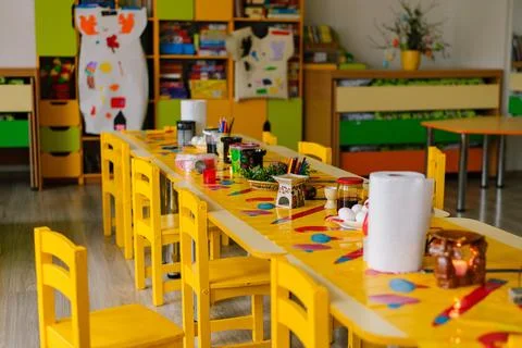 Long yellow table for the workshop in the kindergarten Stock Photos