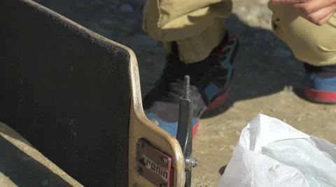 Longboarder assembling red wheels on the longboard on Transalpina Video stock 57786361