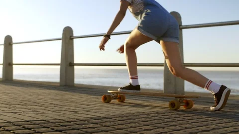 Longboarding by the ocean with sun flare Stock Footage 118618206