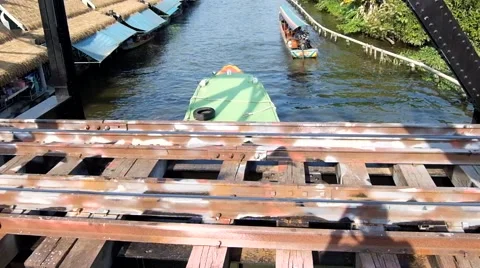 Longtail boat pass under the railway bridge at taling chan floating market Stock Footage 45586652
