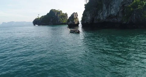 Longtail boat passing between shaded limestone islands Vídeo Stock 71301931